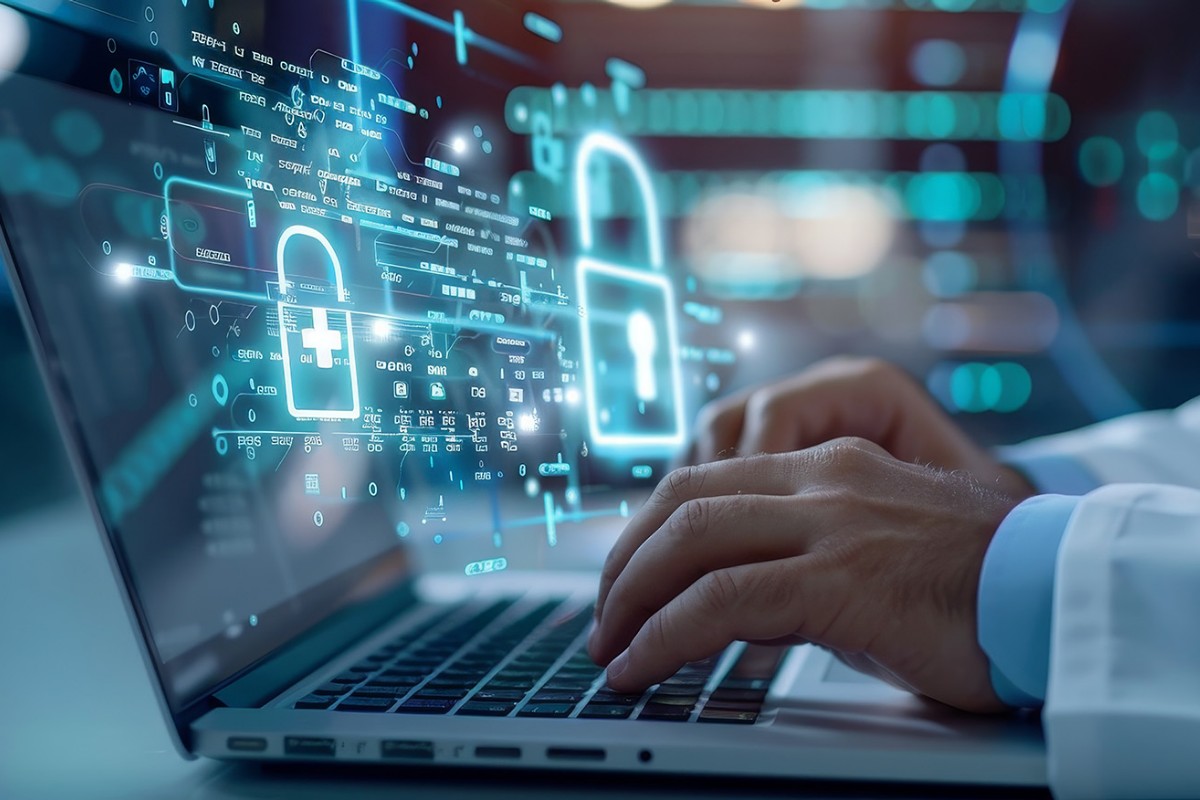 Doctor using a laptop with digital security graphics overlay, representing data protection and cybersecurity in healthcare.